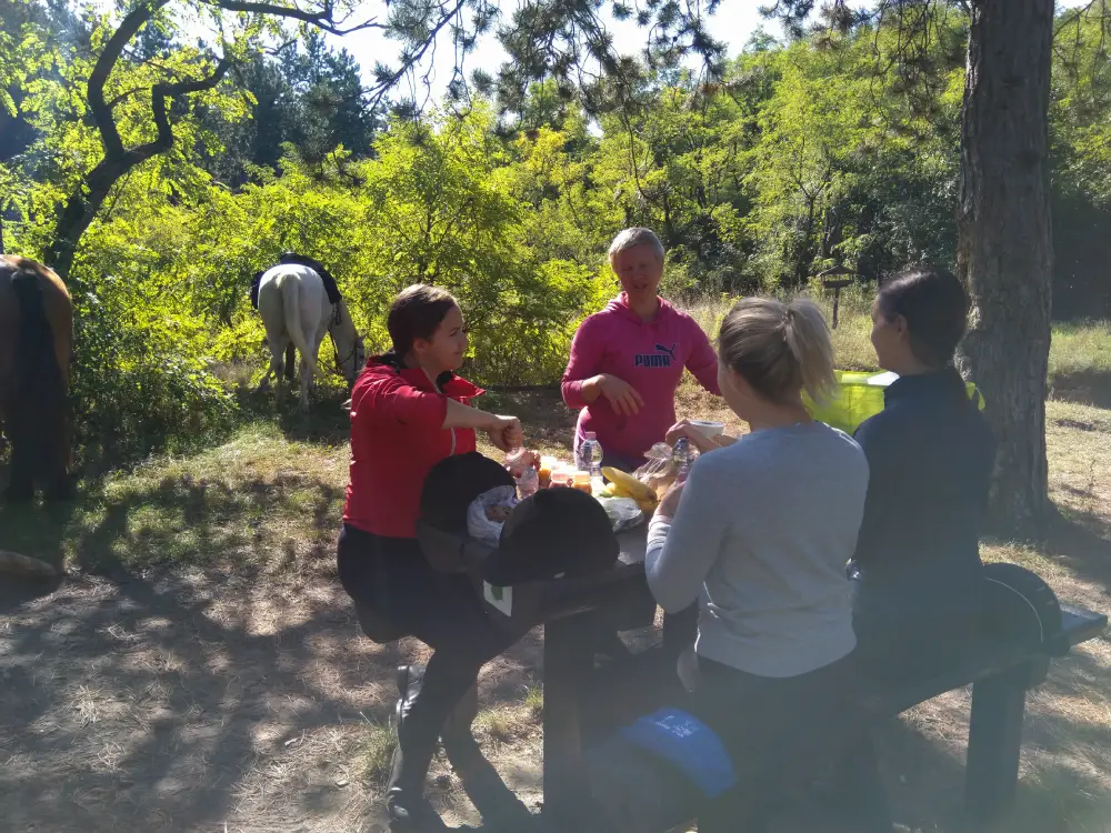 Group of horses riders enjoying a picnic.